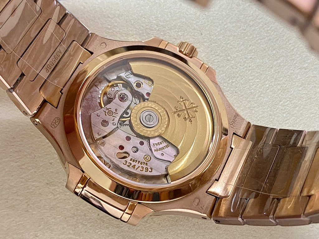 Patek Philippe wristwatch with gold-tone case back and visible mechanical movement, on bracelet