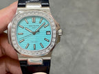Patek Philippe watch with teal dial, diamond-studded bezel, and dark blue leather strap