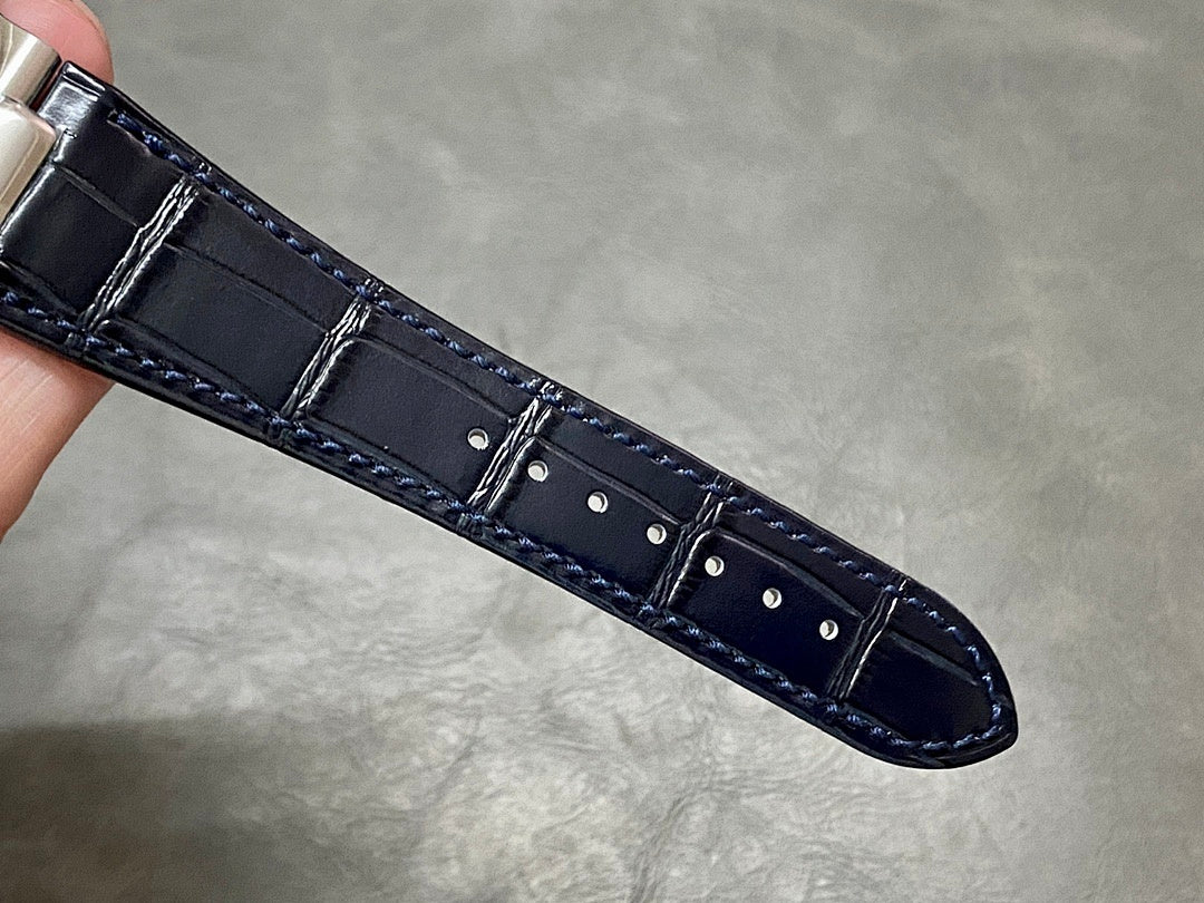 Dark blue leather watch strap with stitched edges and stitched buckle tab