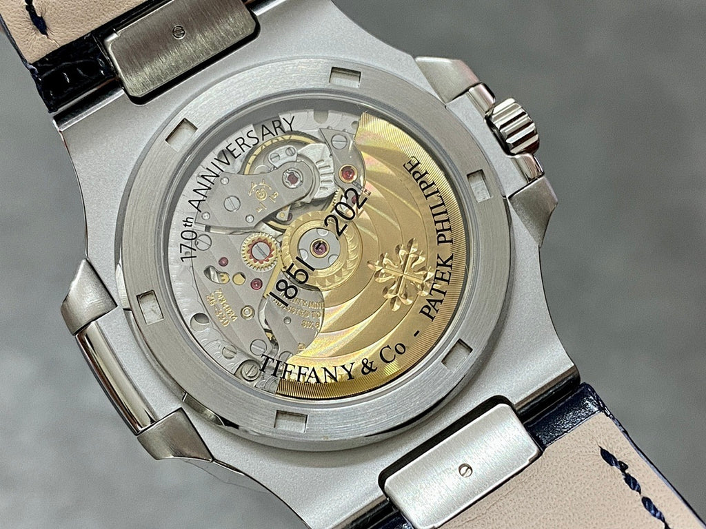 Patek Philippe watch caseback with gold-toned movement and engraved text