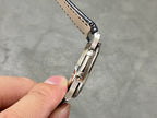 Metal buckle and dark blue leather strap with visible stitching and holes
