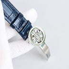 Patek Philippe watch caseback with patterned metal back and navy leather strap