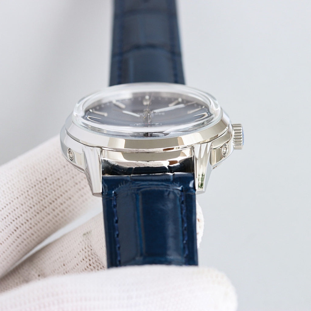 Patek Philippe watch with silver case and navy leather strap, crown on side