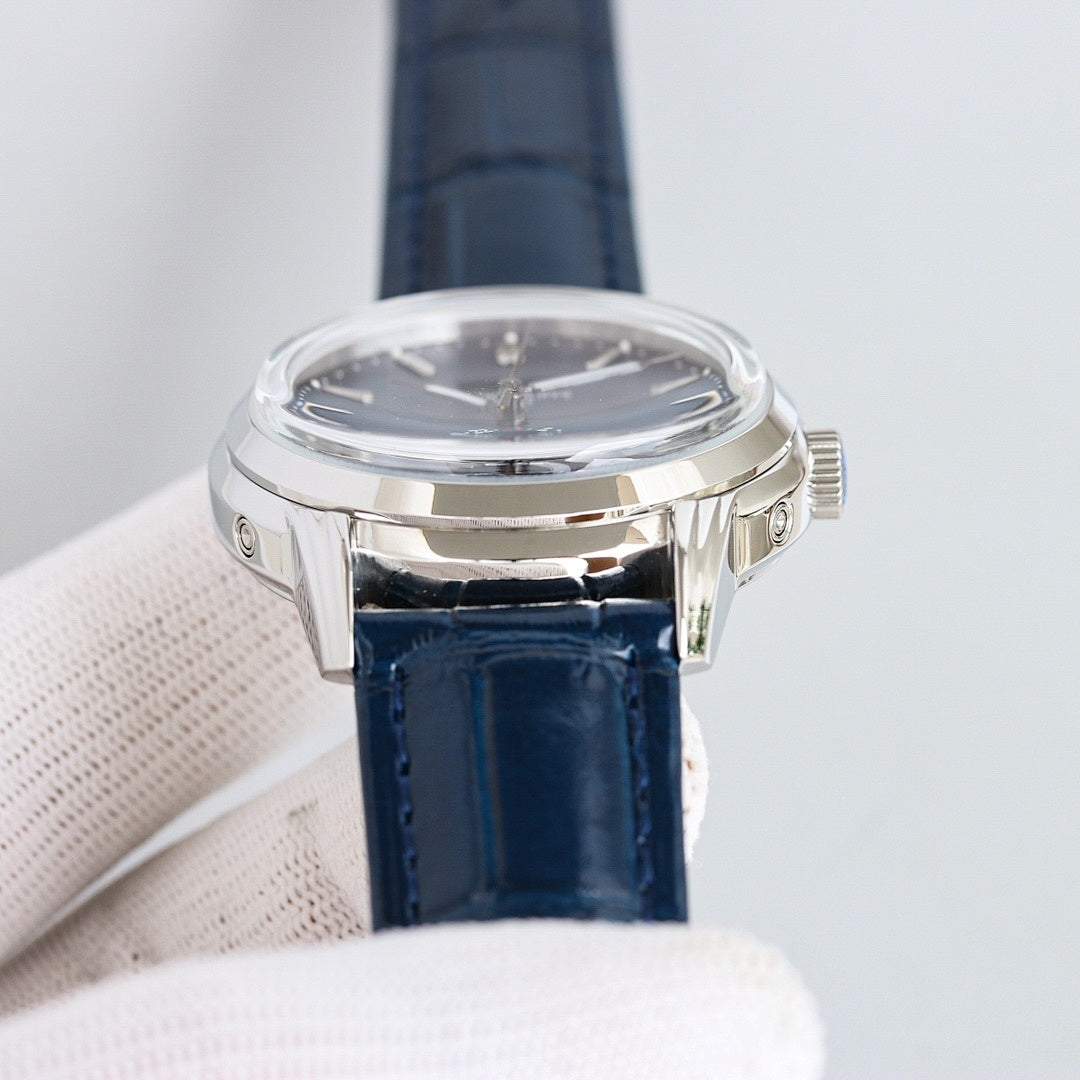 Patek Philippe watch with silver case and navy leather strap, crown on side