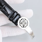 Patek Philippe wristwatch caseback with black leather strap and round metal back