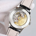 Patek Philippe watch caseback with visible mechanical movement, gold-toned gear parts