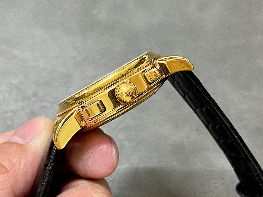 Gold watch side profile with crown and pusher; black leather strap connected.