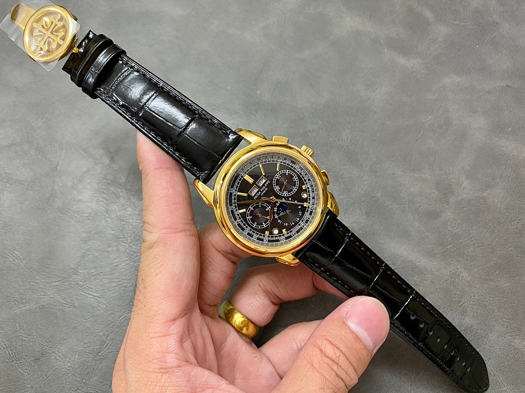 Gold wristwatch on black leather strap with black chronograph dial and subdials.