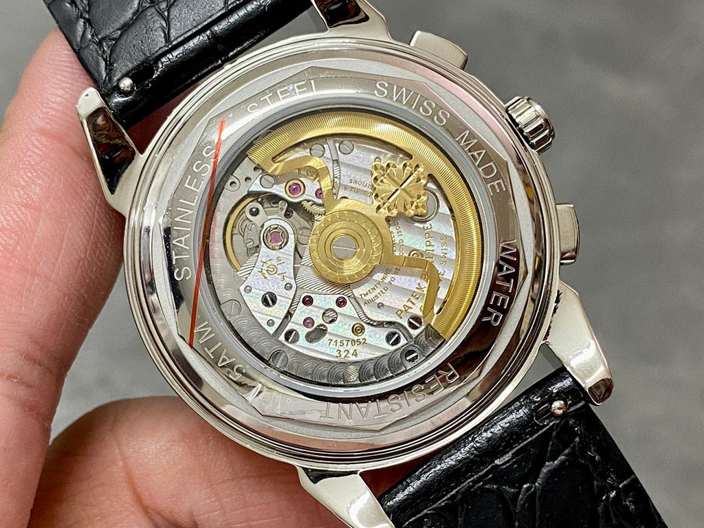Wristwatch with clear caseback showing gold-toned movement, black leather strap