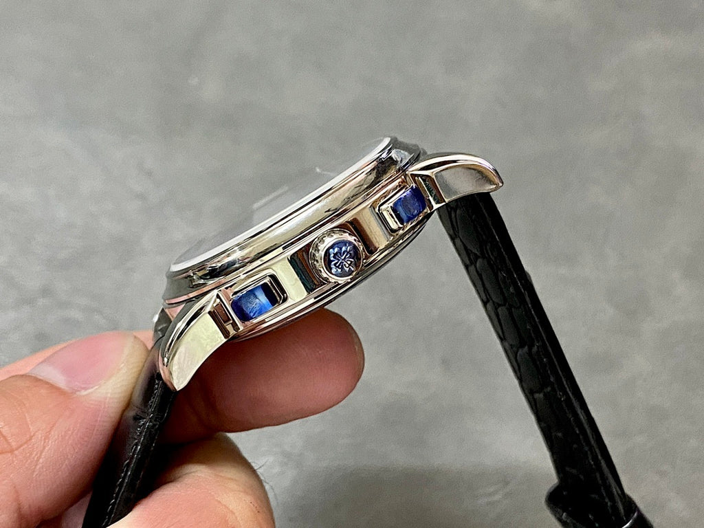 Wristwatch side profile with two blue accents on bezel, black leather strap