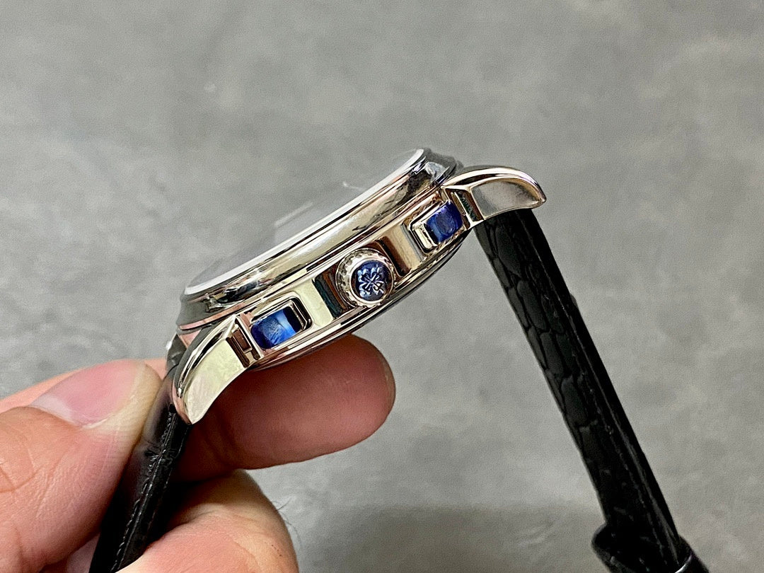 Wristwatch side profile with two blue accents on bezel, black leather strap