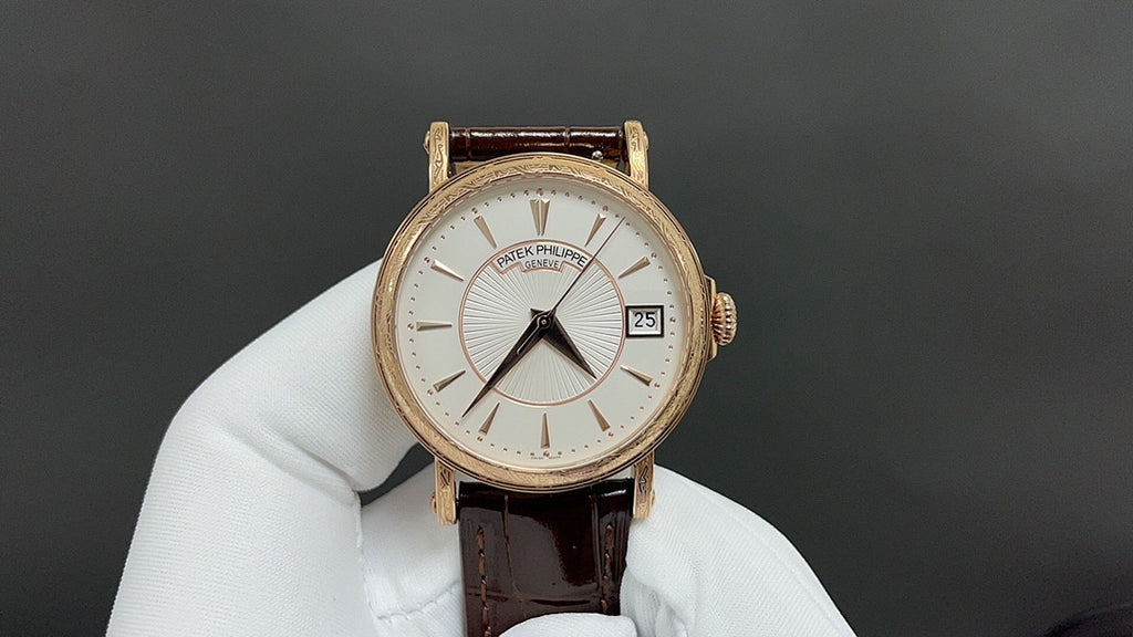 Gold wristwatch with white dial and brown leather strap, round case, baton markers