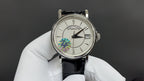 Patek Philippe wristwatch with white dial, black leather strap and silver bezel