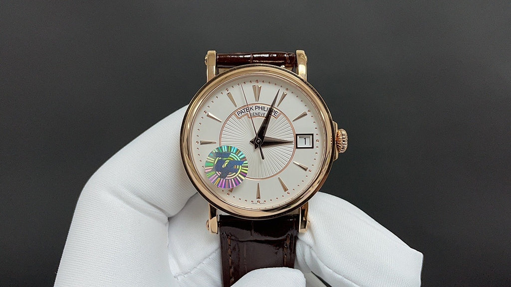 Gold-tone wristwatch on white glove with white dial and brown leather strap, left subdial