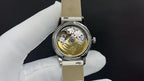 Wristwatch with exposed mechanical movement and light leather strap, stainless case