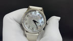 Wristwatch with silver dial, Arabic numerals, black hands, and light leather strap