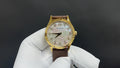 Patek Philippe watch with gold bezel, white dial, brown leather strap