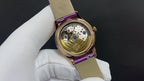 Gold wristwatch with purple leather strap, caseback view with engraved details
