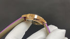 Gold wristwatch case with purple leather strap, side profile and crown