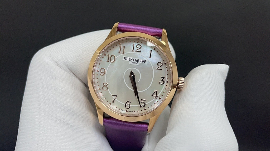 Gold wristwatch with purple leather strap, white dial with Arabic numerals