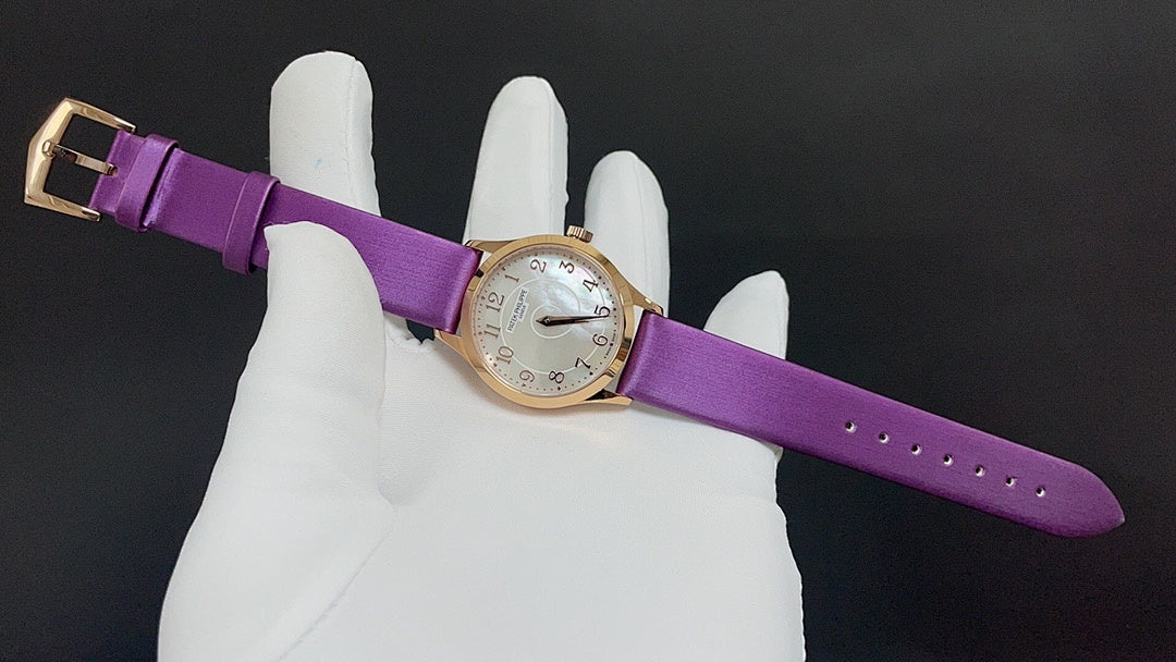 Gold wristwatch with purple leather strap, buckle and watch face visible