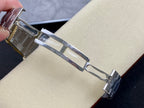 Stainless steel watch bracelet clasp link close-up on Patek Philippe wristwatch.