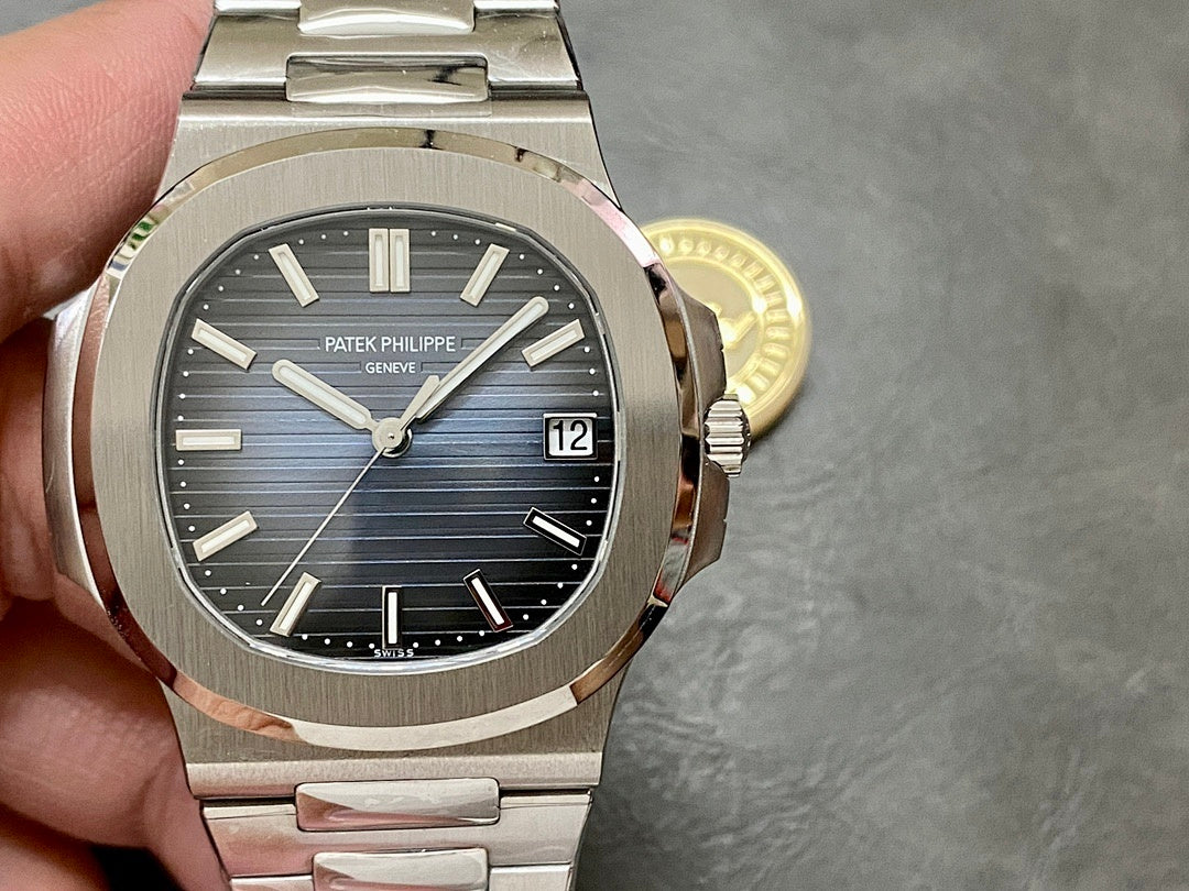 Patek Philippe stainless watch on wrist, blue dial with baton markers and date window