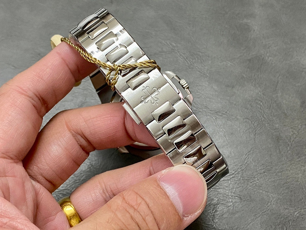 Patek Philippe metal bracelet with polished links and gold-toned accents near the clasp