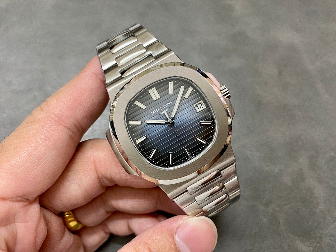 Patek Philippe stainless watch with blue dial, baton hands, and date window at 12