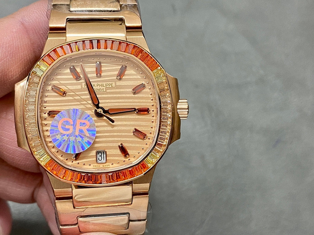 Gold-tone Patek Philippe wristwatch with champagne dial, red bezel detail, metal bracelet