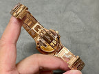 Gold-tone Patek Philippe wristwatch with metal link bracelet, side view