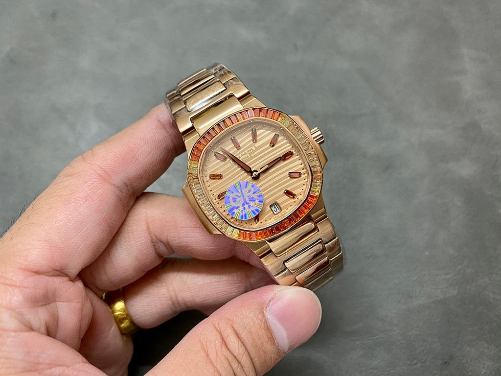Gold-tone Patek Philippe wristwatch with champagne dial, red bezel, metal bracelet