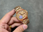 Gold-tone Patek Philippe wristwatch with champagne dial, red bezel, metal bracelet