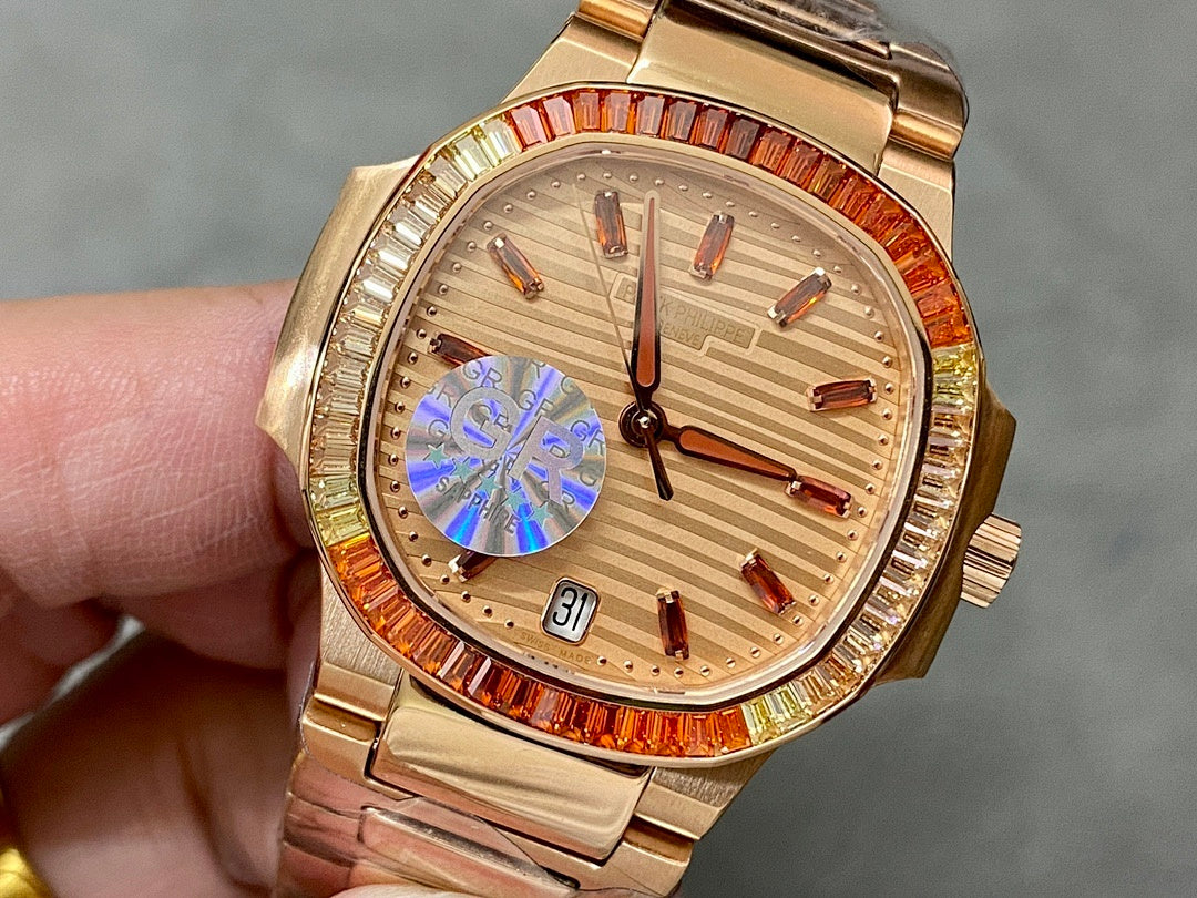 Gold-tone Patek Philippe wristwatch with champagne dial, red jeweled bezel, metal bracelet