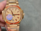 Gold-tone Patek Philippe wristwatch with champagne dial, red bezel, metal bracelet