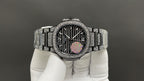 Patek Philippe watch with diamond bezel, dark dial, and silver bracelet