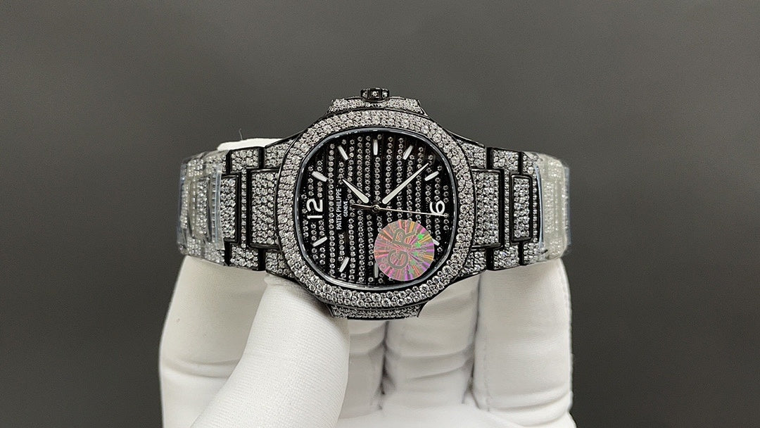 Patek Philippe watch with diamond bezel, dark dial, and silver bracelet
