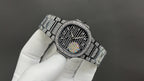 Patek Philippe watch with diamond bezel and dark dial on silver link bracelet