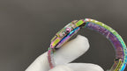 Jeweled wristwatch clasp on iridescent rainbow bracelet with round decorated case