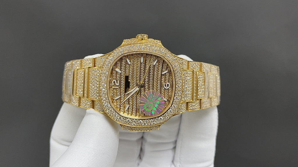 Gold-tone wristwatch with diamond bezel, textured dial, and colorful center motif