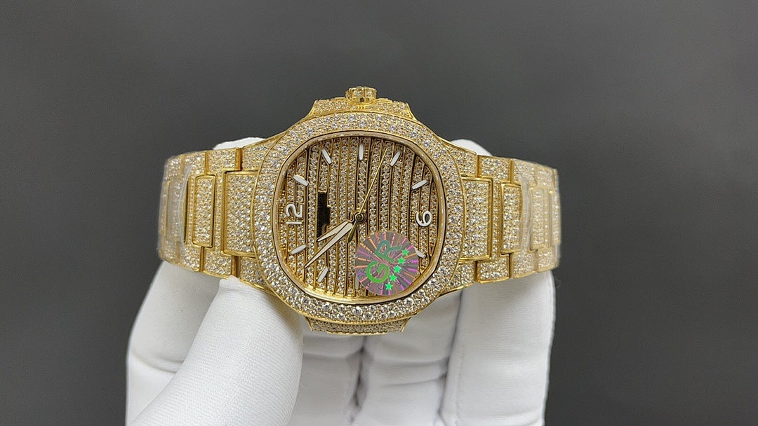 Gold-tone wristwatch with diamond bezel, textured dial, and colorful center motif