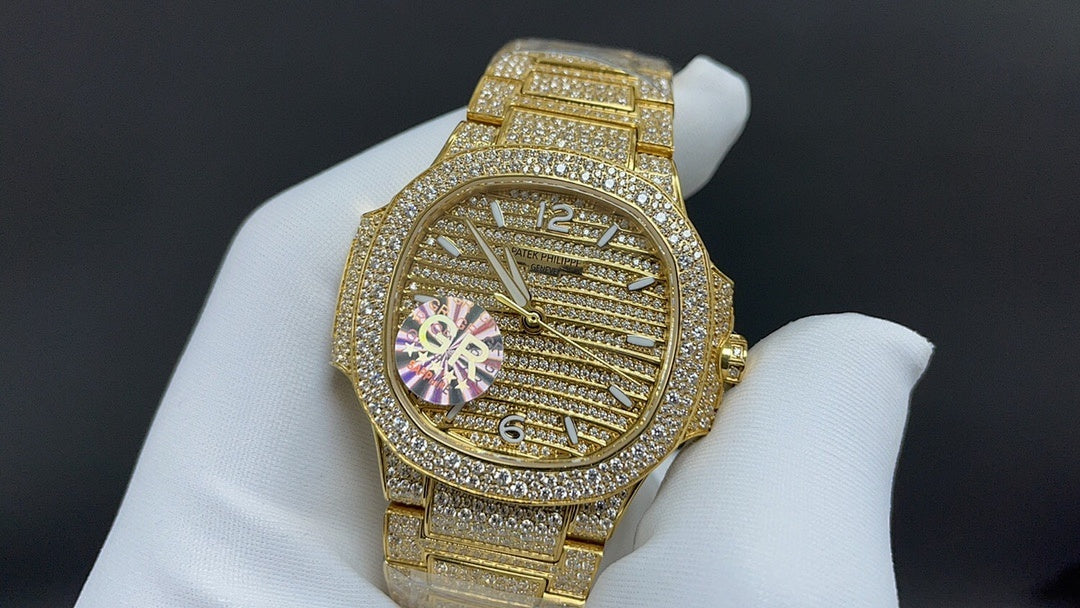 Gold-tone wristwatch with diamond bezel and ornate dial with colorful flower-like accents
