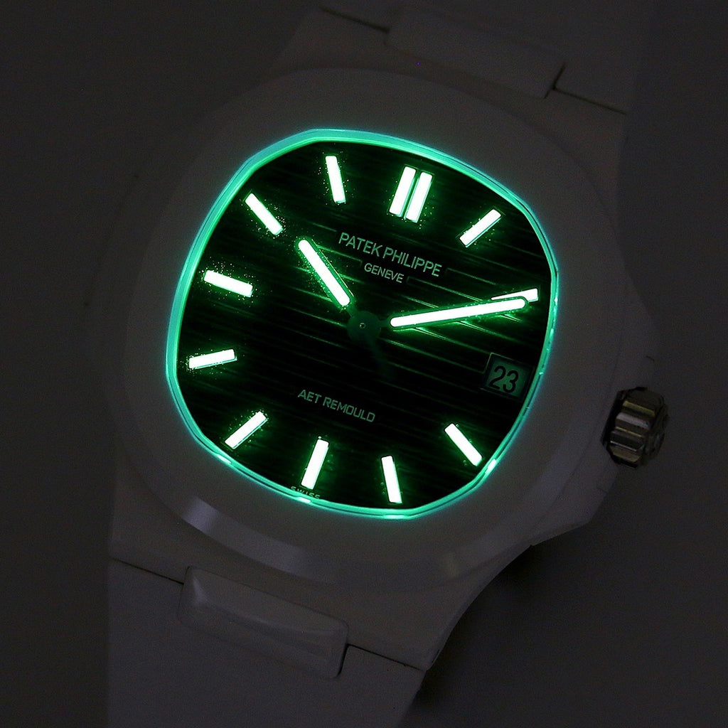 Patek Philippe watch, green glowing hands on black dial in low light, date window.