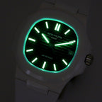 Patek Philippe watch, green glowing hands on black dial in low light, date window.