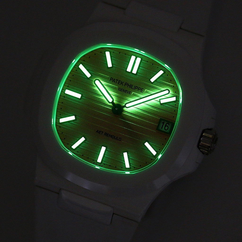White rubber wristwatch with green glowing dial at night, black markers, date window
