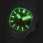 White rubber wristwatch with green glowing dial at night, black markers, date window