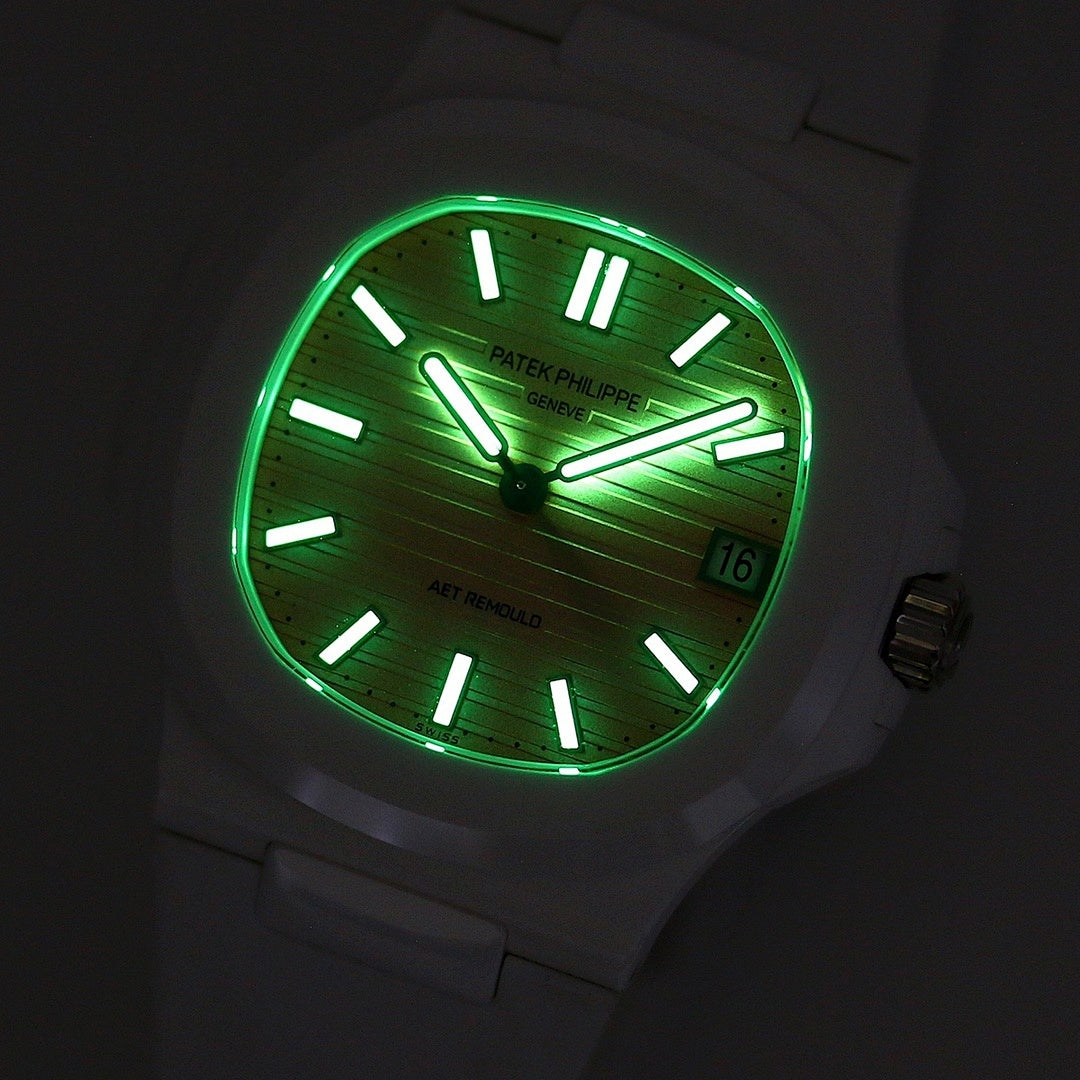White rubber wristwatch with green glowing dial at night, black markers, date window
