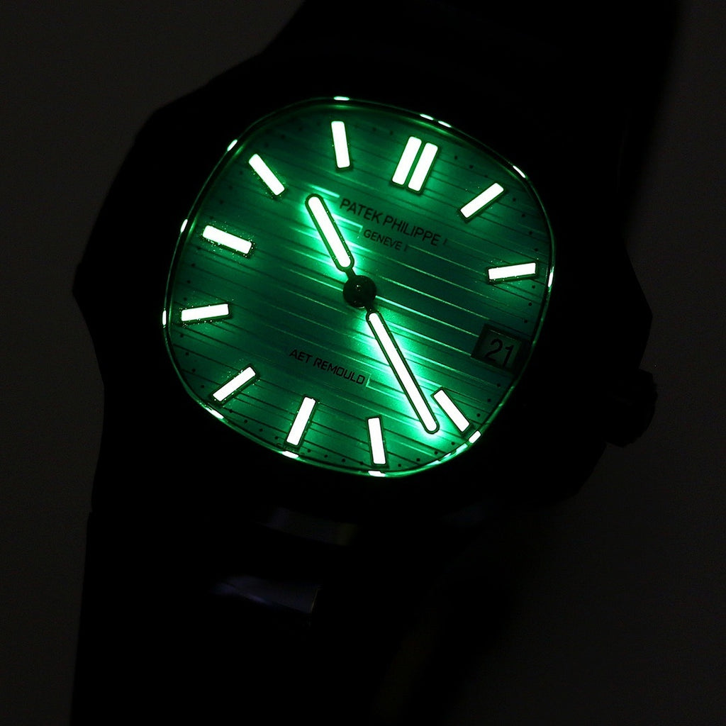 Patek Philippe watch with glowing turquoise lume dial, black bezel and strap.