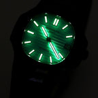 Patek Philippe watch with glowing turquoise lume dial, black bezel and strap.