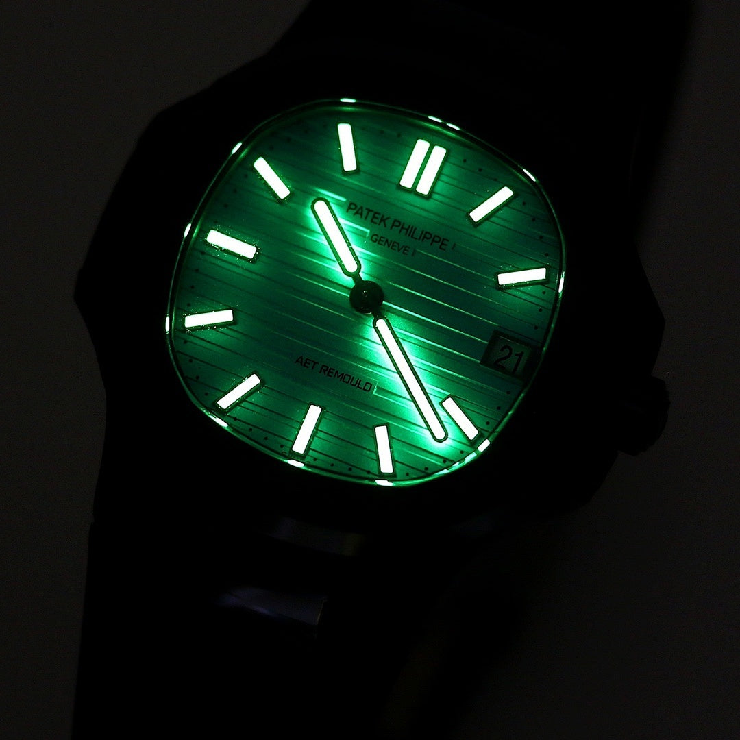 Patek Philippe watch with glowing turquoise lume dial, black bezel and strap.